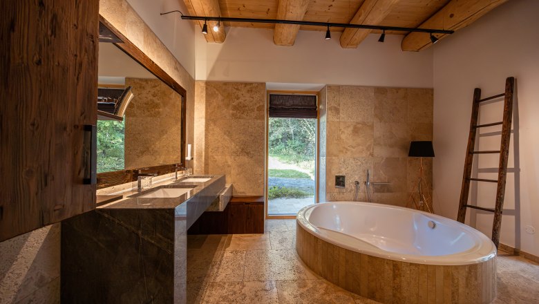 Rekreační dům u jezera, © Niederösterreich Werbung / Maximilian Pawlikowsky Moderní koupelna s volně stojící vanou, velkým zrcadlem a dřevěným trámovým stropem.
