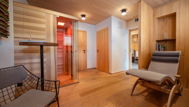 Weinviertler Kellerstöckl Vinařství Hindler, © Niederösterreich Werbung / Maximilian Pawlikowsky Pohled do interiéru moderního pokoje s dřevěným obložením, lehátkem a infračervenou kabinou.