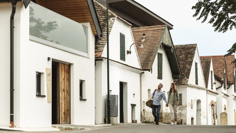 Vinařství Hagn Kellerstöckl, © Weinviertel Tourismus GmbH Pár se prochází kolem tradičních vinných sklepů.