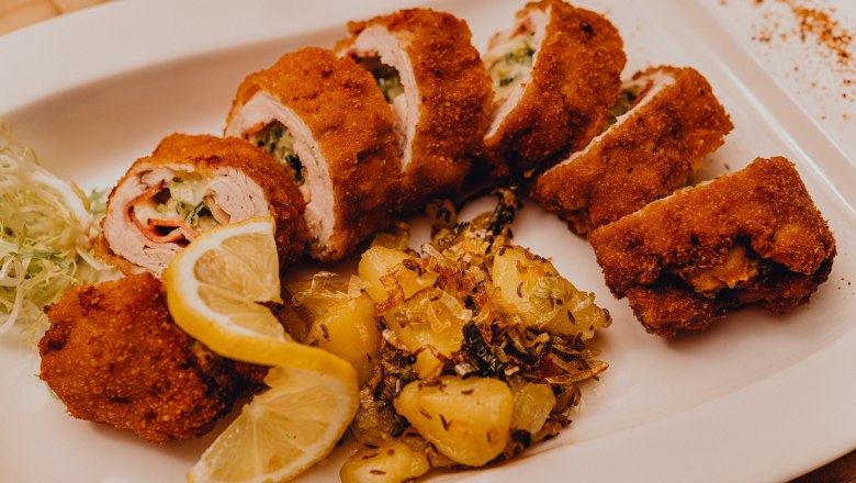 Plněné pečené krůtí filé, © Niederösterreich Werbung/Klaus Engelmayer Plněné pečené krůtí filé s bramborovou přílohou a plátky citronu na bílém talíři.