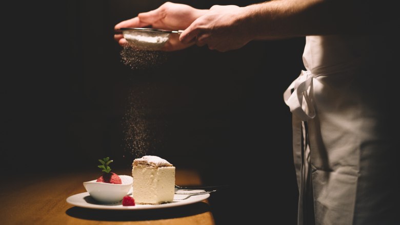 Když se smetanový plátek potká s malinovým sorbetem... mmmh...., © Niederösterreich Werbung/Mara Hohla Talířek se šlehačkou a malinovým sorbetem, posypaný moučkovým cukrem.