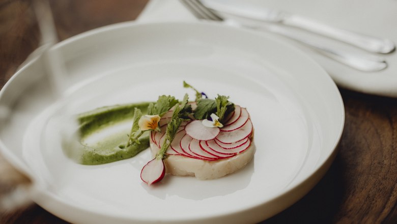 Skvělá kombinace: char, wasabi, ředkvičky, © Niederösterreich Werbung/Sophie Menegaldo Pokrm s uhlem, ředkvičkami a wasabi krémem, zdobený jedlými květy.