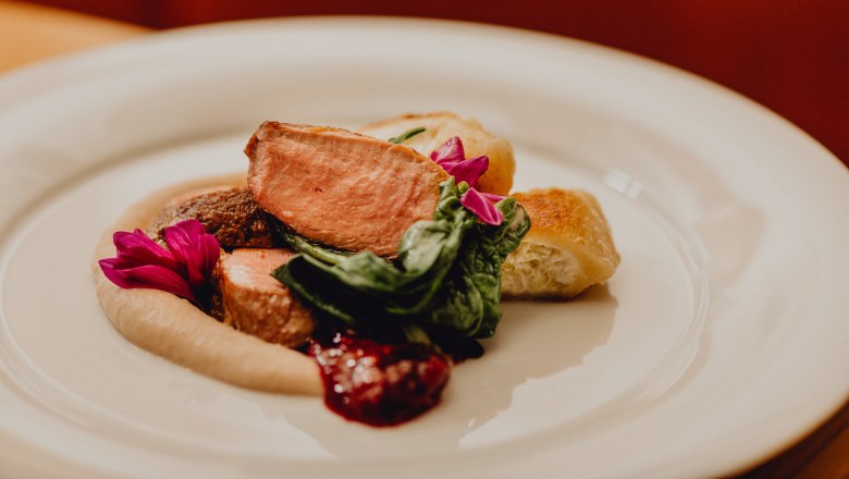 Růžová pečená kachna se smetanovými tartaletkami a kaštanovým pyré, © Niederösterreich Werbung/Klaus Engelmayer Talíř s růžovou pečenou kachnou, smetanovými tartaletkami, kaštanovým pyré a zelenými listy, zdobený jedlými květy.