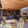 Boutique hotel WeinSpitz, © Niederösterreich Werbung / Maximilian Pawlikowsky Pohled do interiéru vinárny s dřevěnými prvky, zelenými židlemi a barem v pozadí.