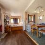 SONNENTOR country lofts, © Niederösterreich Werbung / Maximilian Pawlikowsky Pohled do interiéru útulného venkovského podkroví s dřevěnou podlahou, jídelním stolem, židlemi, postelí a policemi.