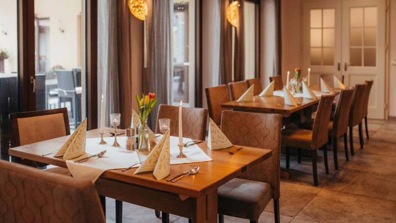 Hospoda s kabaretními večery a ranním pivem, © Niederösterreich Werbung/Daniela Führer Útulný stůl v hospodě se svíčkami a květinami.