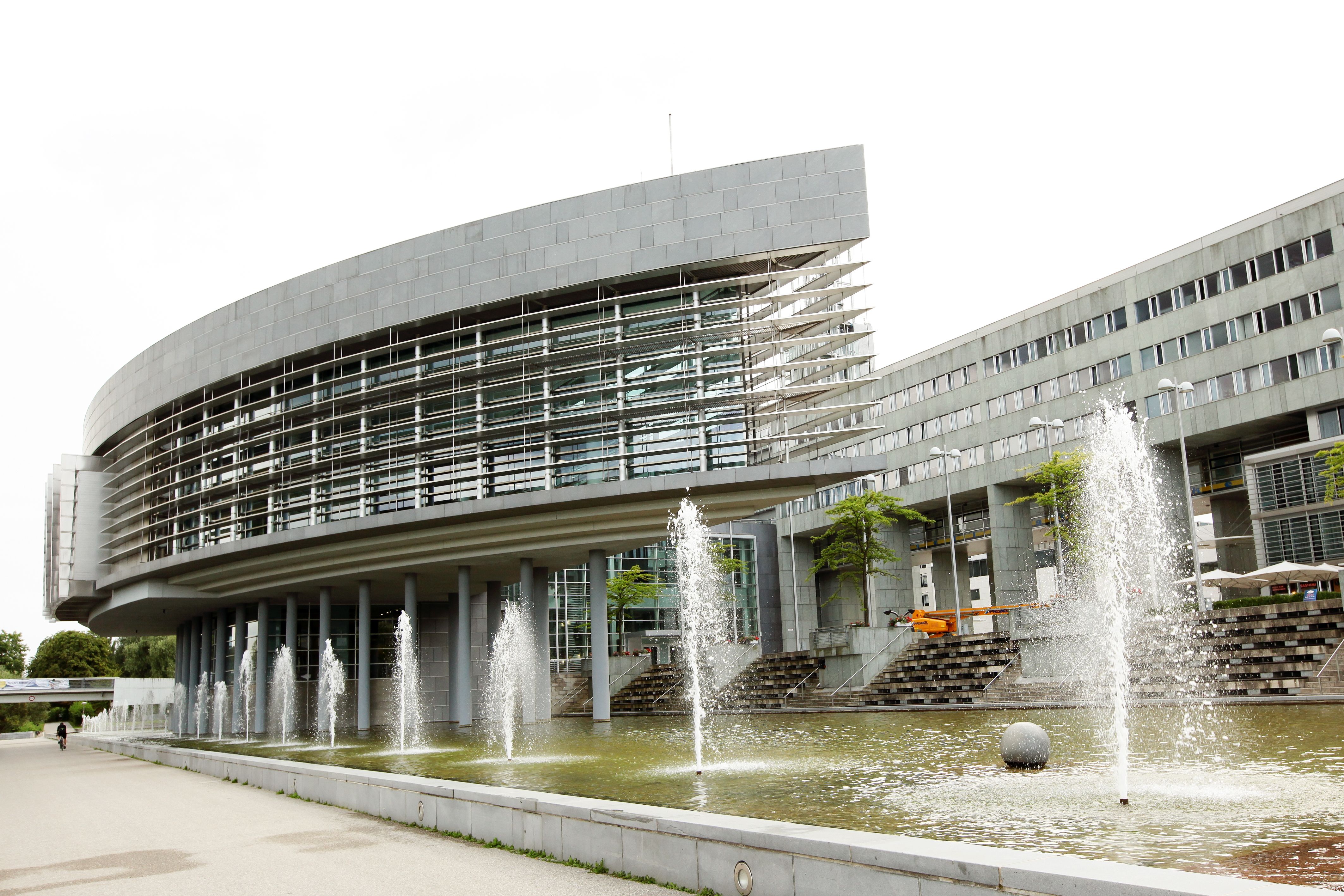 Landhaus St. Pölten s moderními stavebními konstrukcemi a kašnou v popředí.