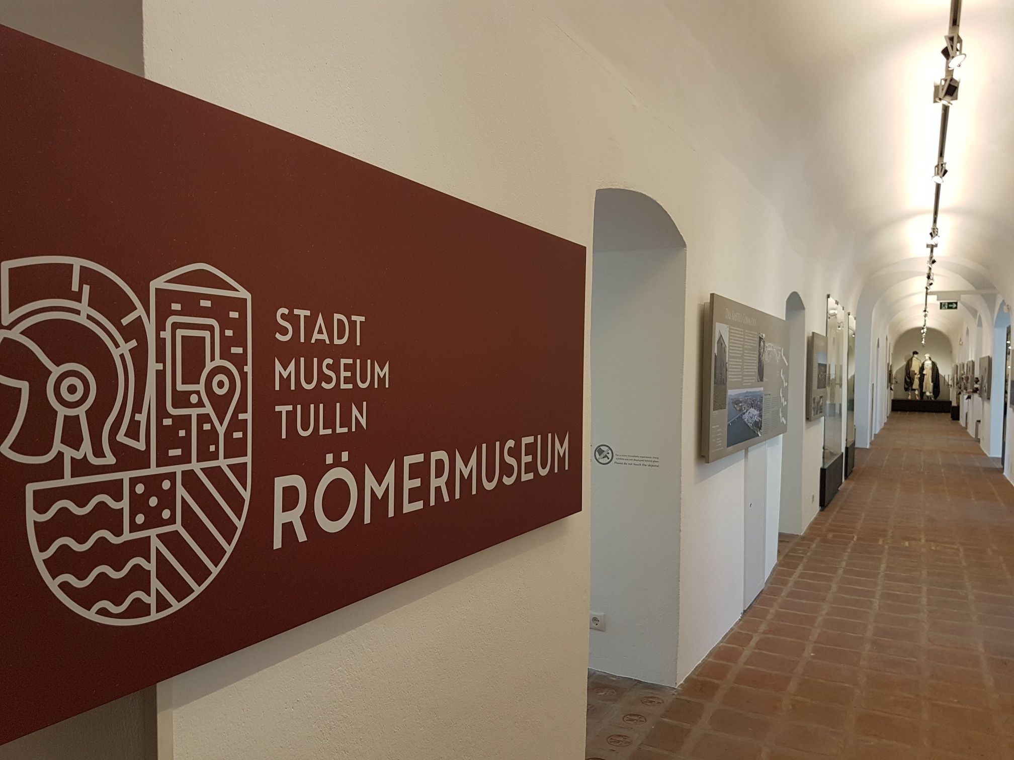 Pohled do interiéru Městského muzea v Tullnu Římské muzeum s dlouhou chodbou a exponáty na stěnách.