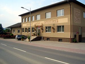 Dvoupatrová budova s nápisem "Gasthof Kögl".
