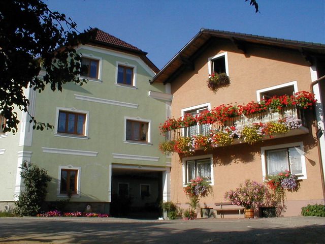 Dvě hospodářské budovy s barevnými květinami na balkonech.