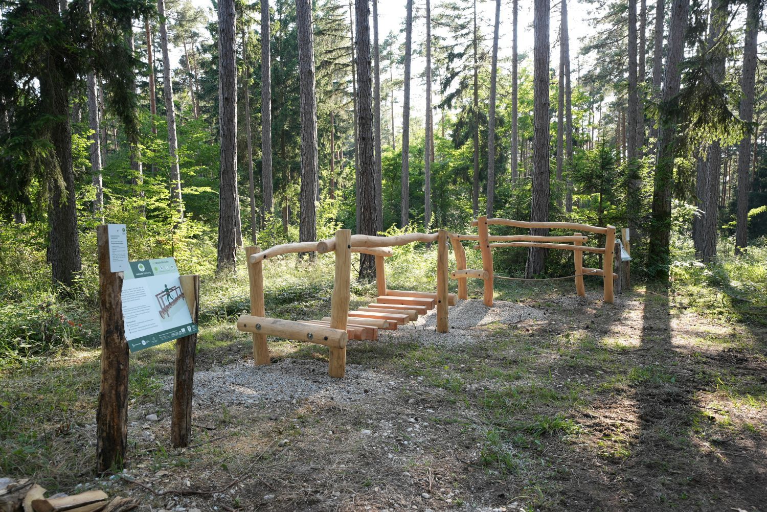 Dřevěné zařízení v lese s informační tabulí v léčivém lese Göttweig.