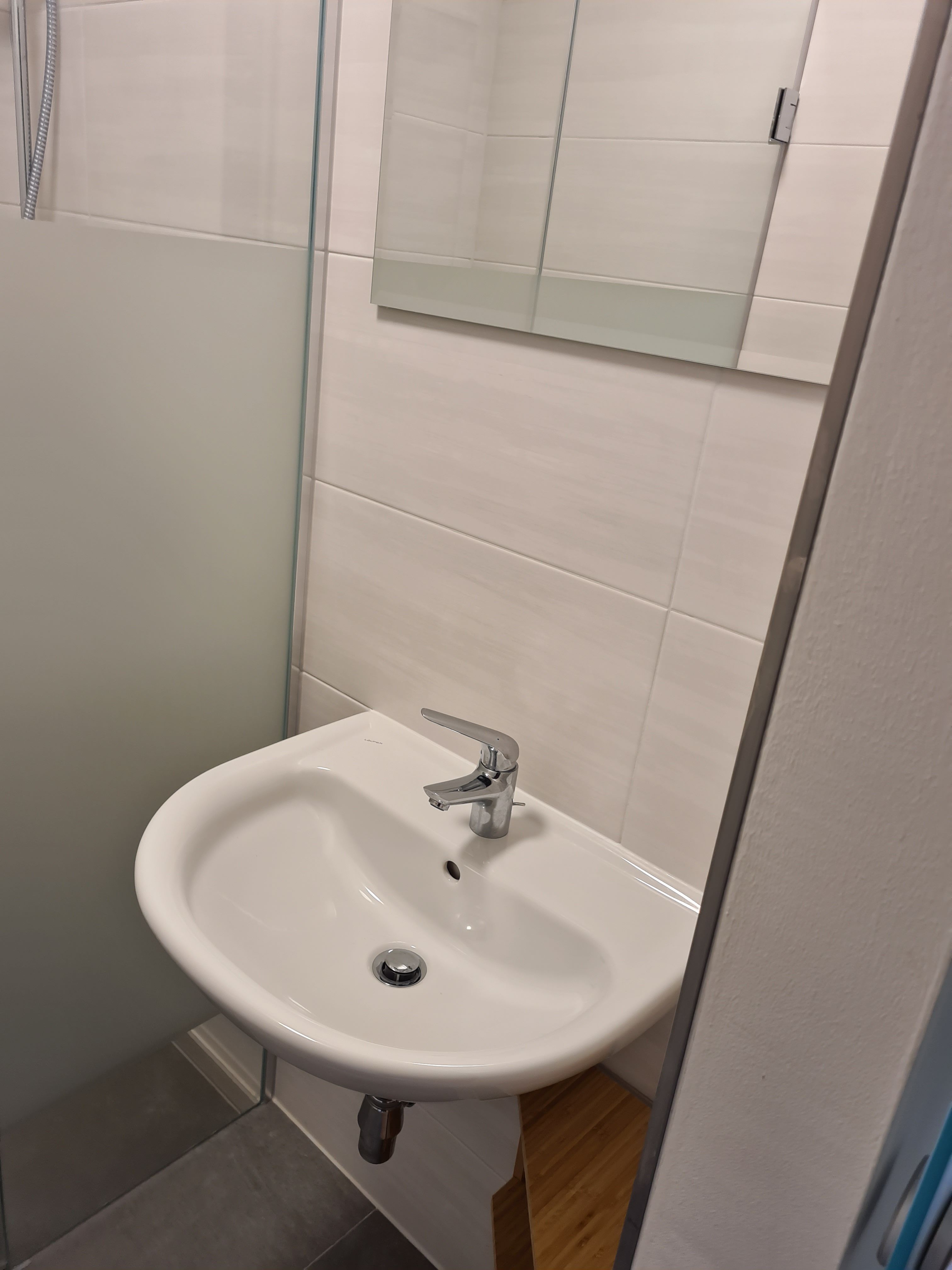 Moderní koupelna s umyvadlem a zrcadlem.