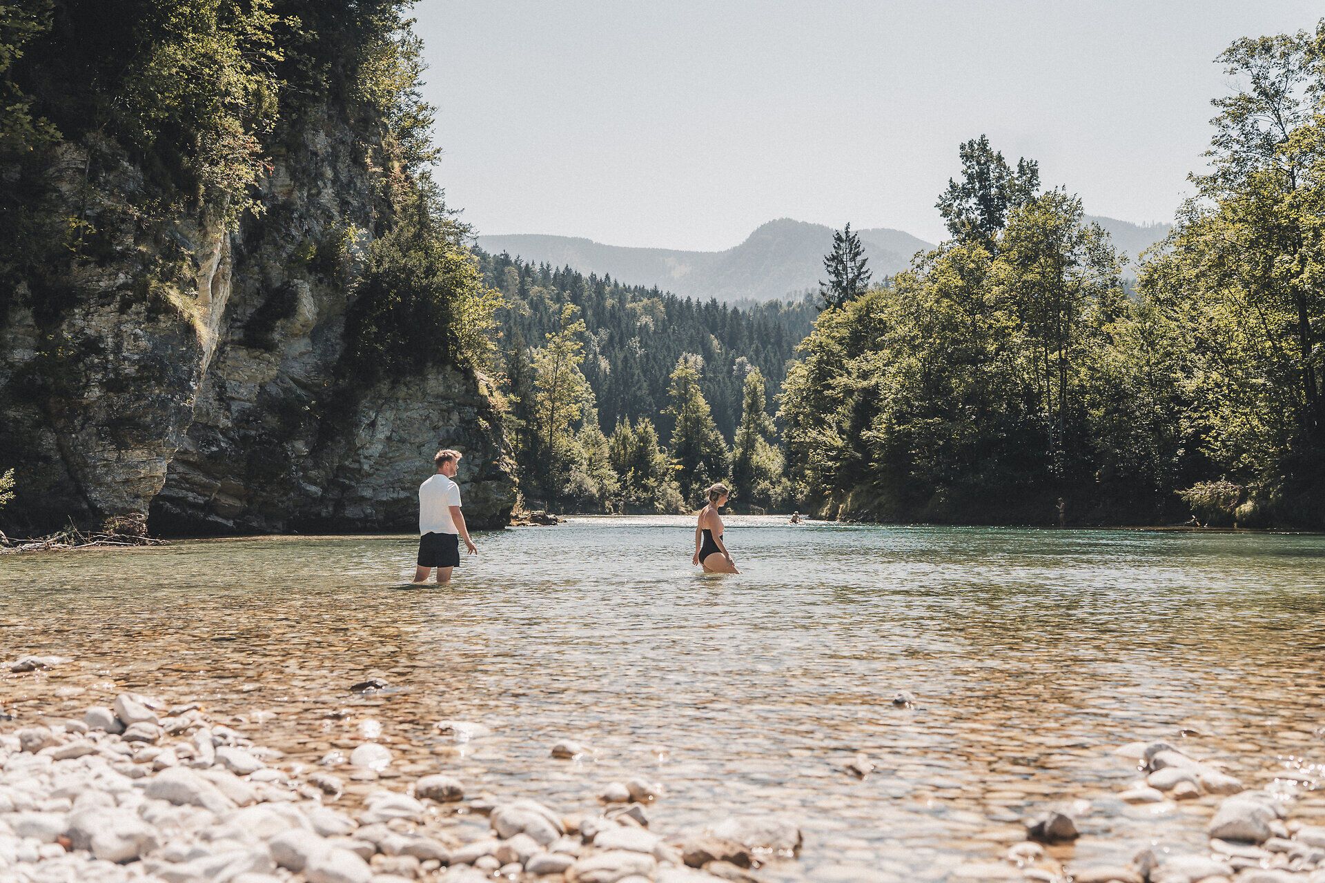 Paar watet im Fluss entlang des Ybbstalradwegs