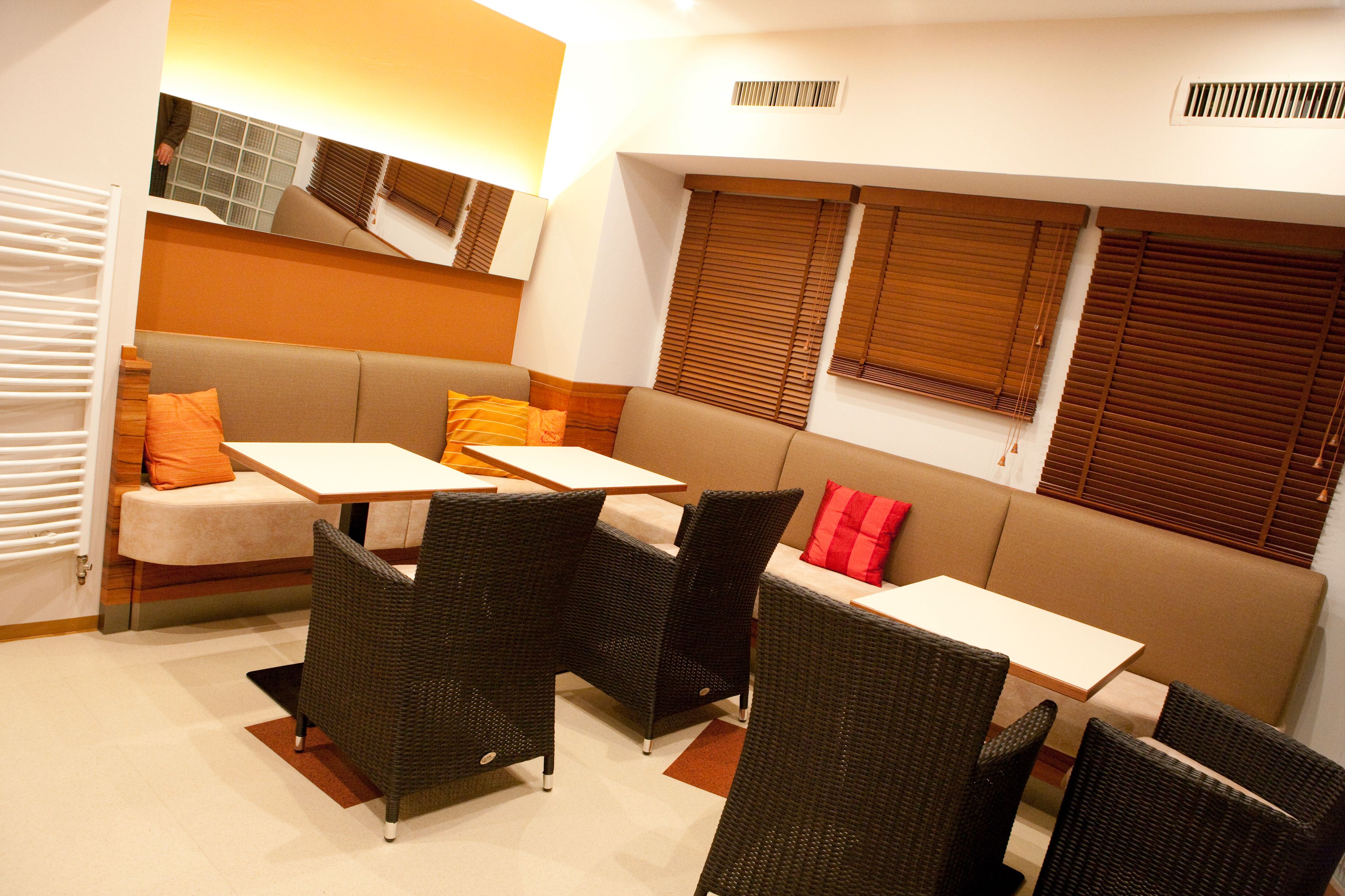 Útulný obývací pokoj s pohovkami, stoly a židlemi.