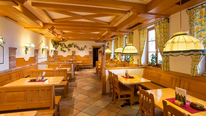 Pohled do interiéru tradiční vinárny s dřevěným nábytkem a útulným osvětlením.