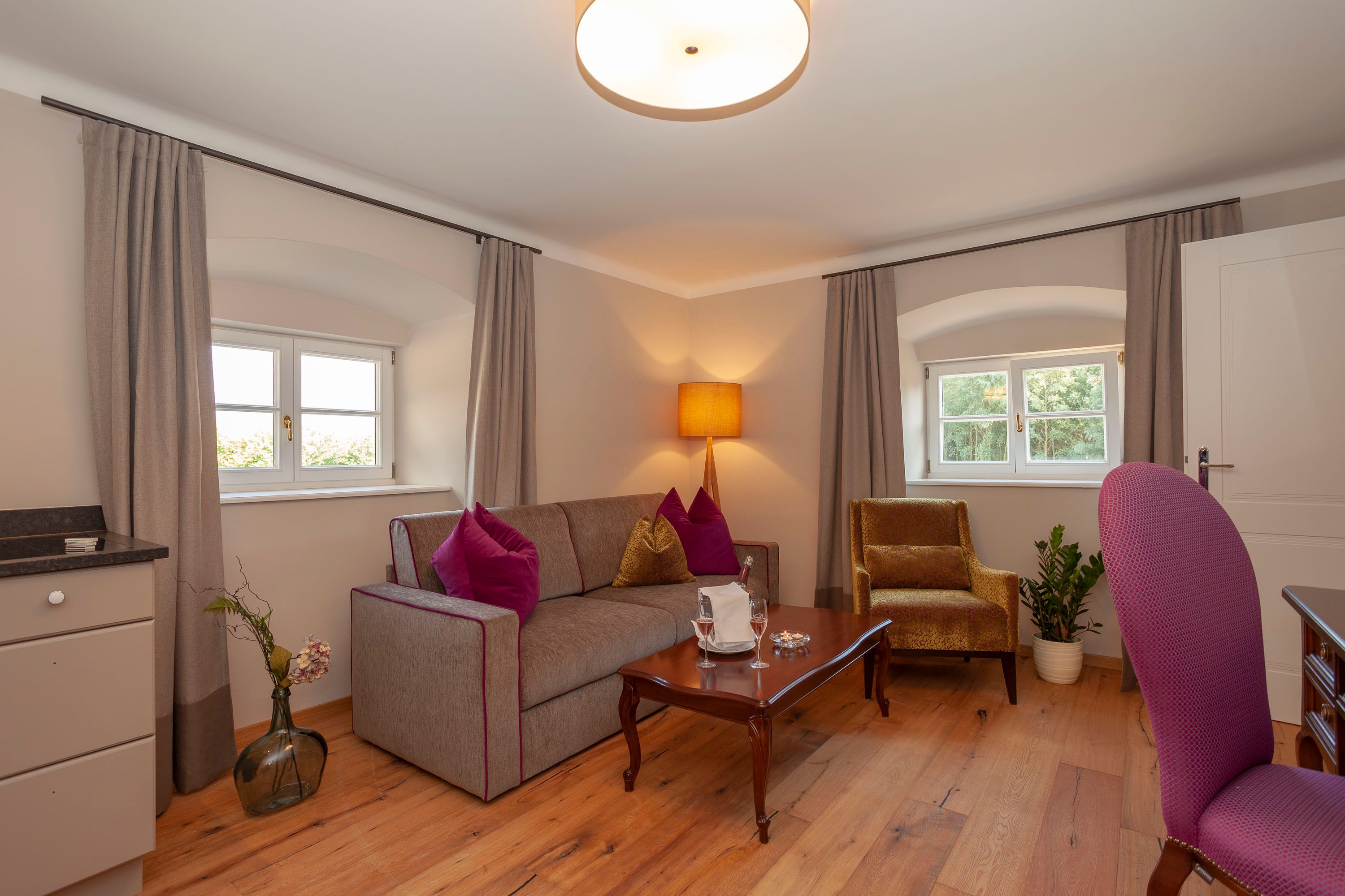 Elegantní apartmá s pohovkou, křeslem, stolem a dekoracemi.