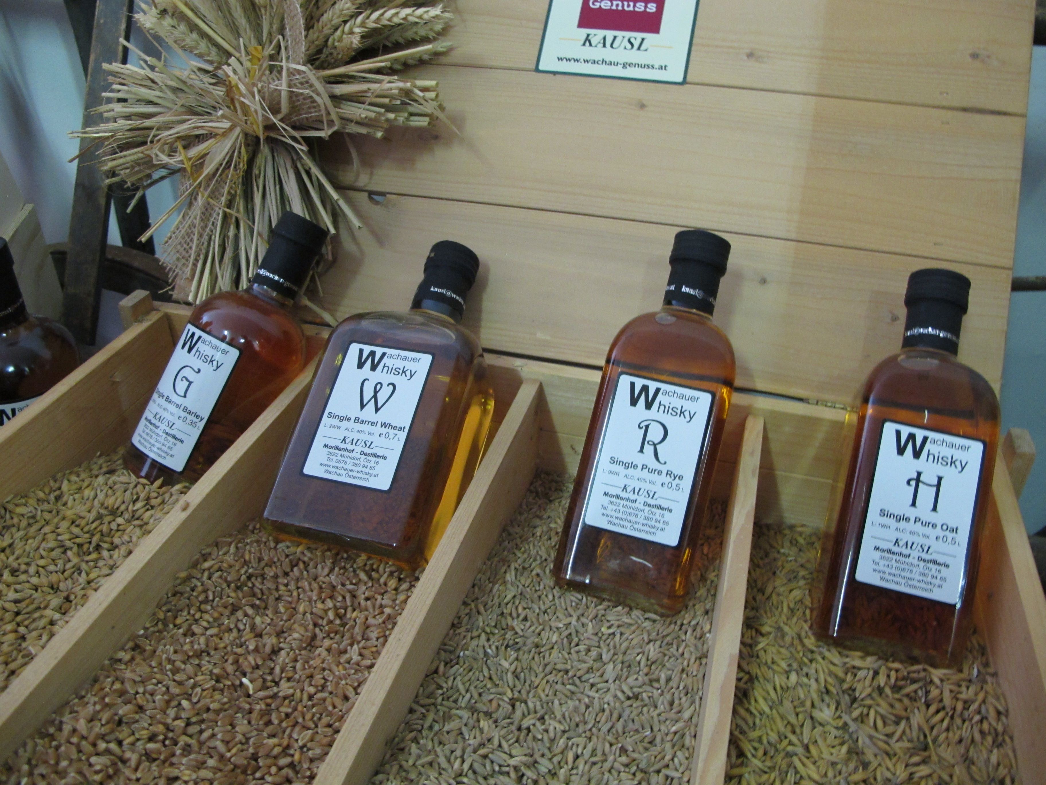 Lahve whisky Wachau vystavené na obilných zrnech.