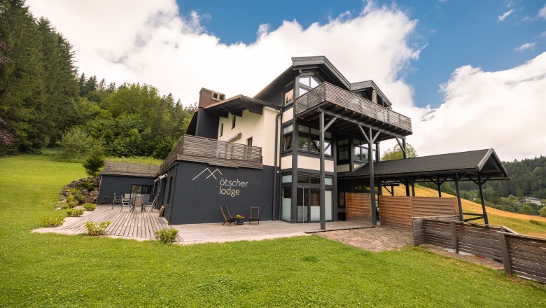 Ötscher Lodge, © Niederösterreich Werbung / Maximilian Pawlikowsky Ötscher Lodge v zeleném, zalesněném prostředí s modrou oblohou.