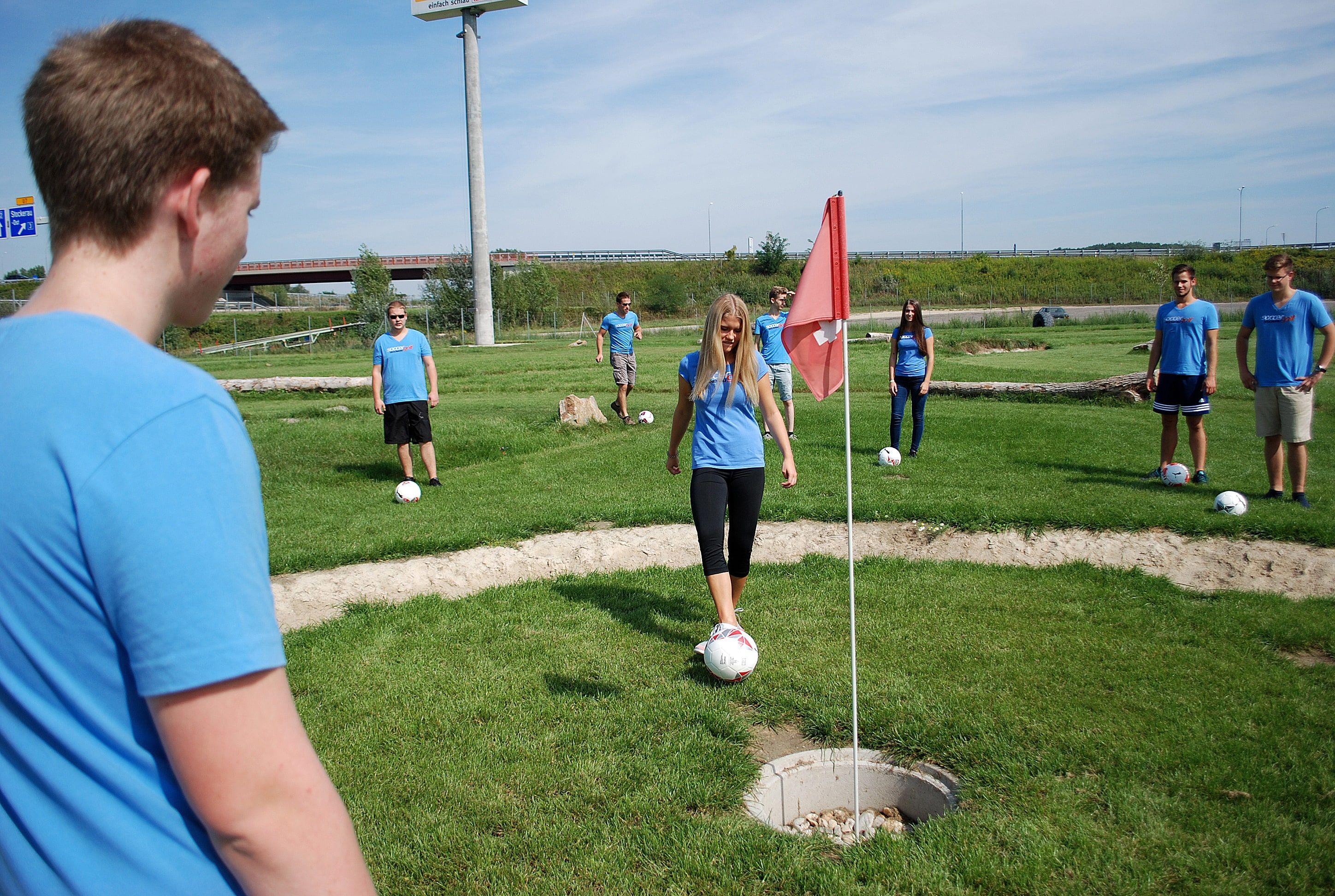 Skupina mladých lidí hrajících Soccergolf.