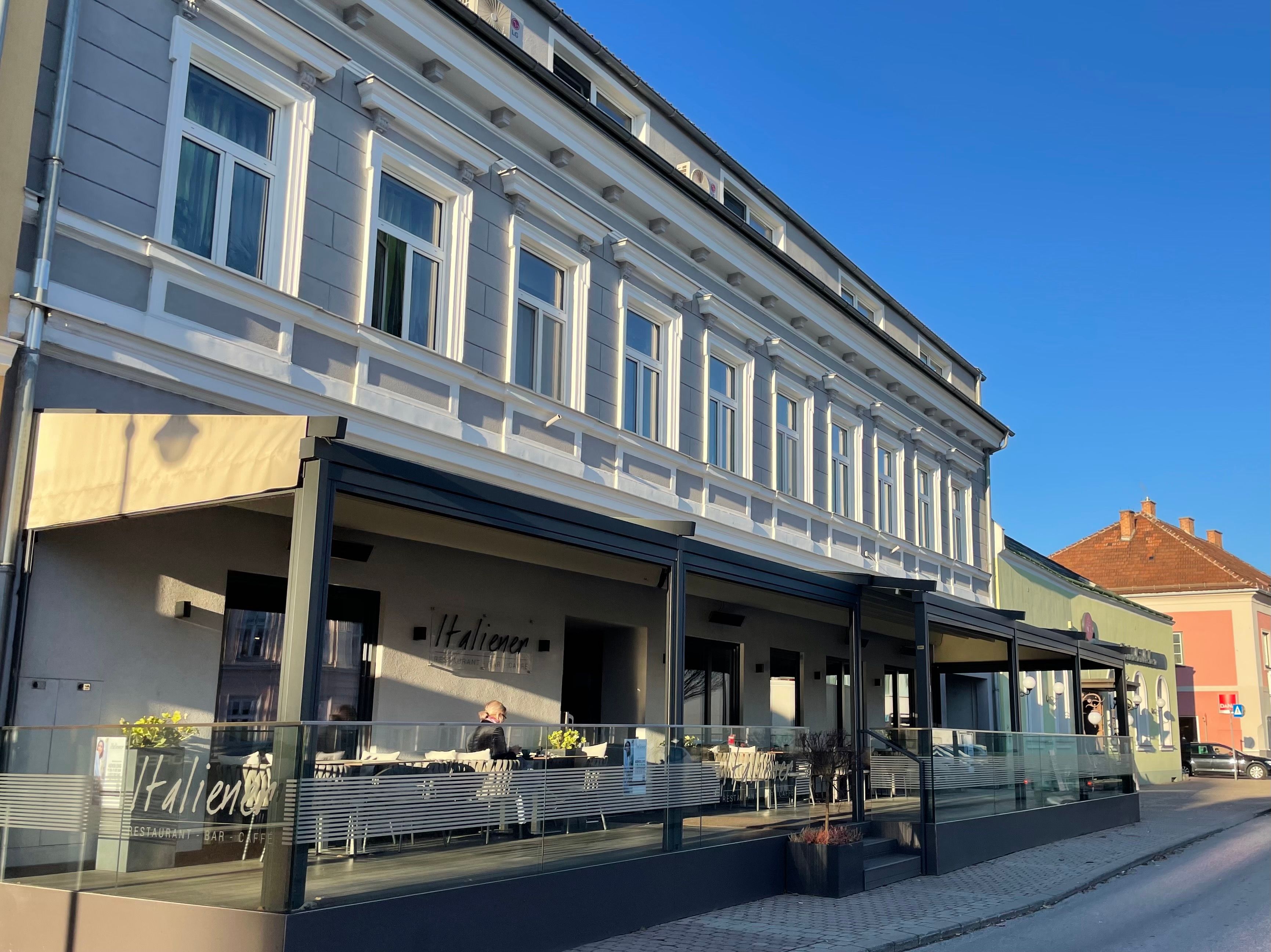 Pohled zvenčí na italskou restauraci s terasou
