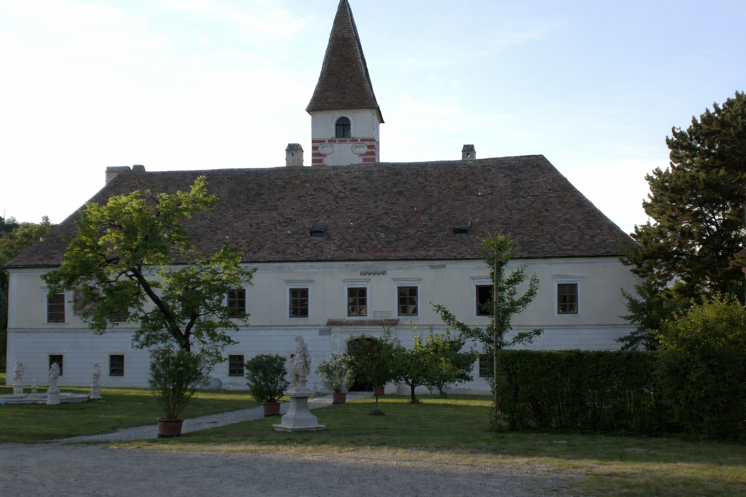 Hrad Limberg se zahradou a sochami v popředí.