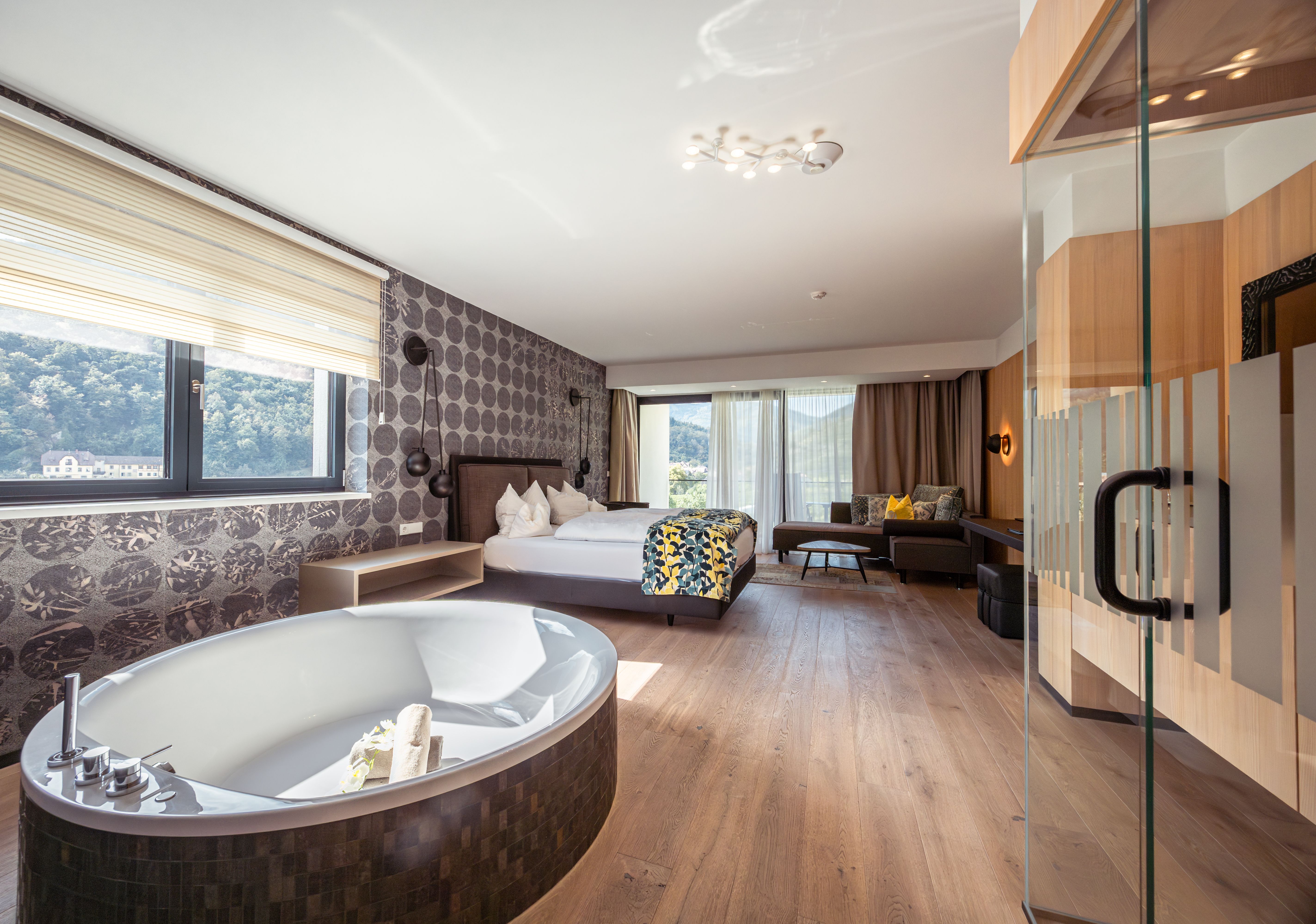 Pohled zvenčí na moderní hotel s bazénem a lehátky.