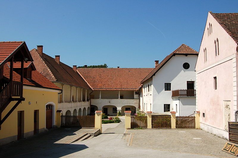 Vnitřní nádvoří zámku Dominikalhof Bromberg s historickými budovami a červenými taškovými střechami.
