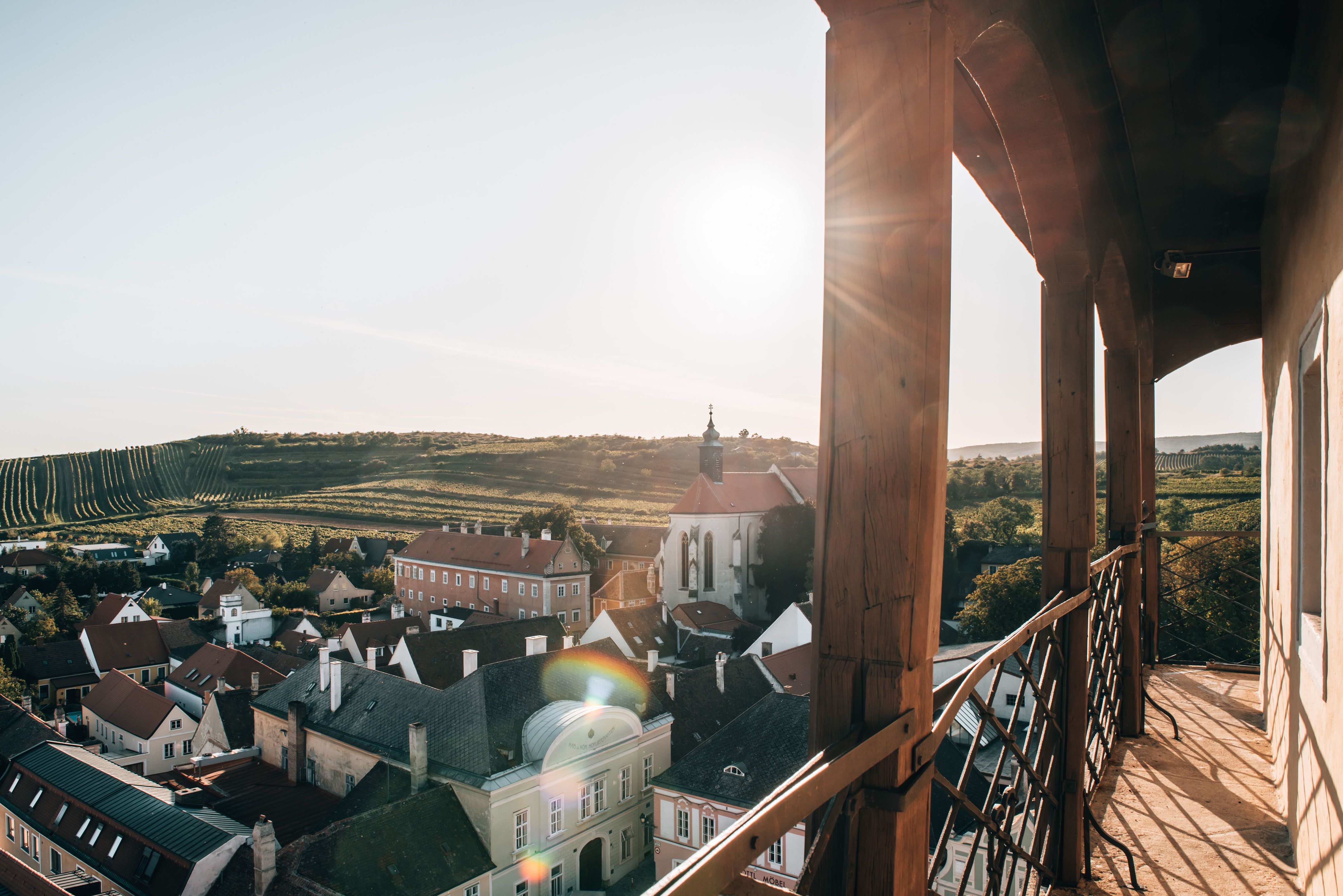 Die sanften Hügel des Weinviertels erstrahlen im warmen Licht des Herbstes, während die Weinreben in leuchtenden Farben leuchten. Ein malerischer Blick auf die charmanten Häuser und die umgebende Landschaft lädt dazu ein, die Ruhe und Schönheit dieser Region zu genießen.