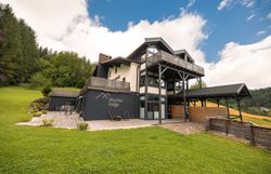 Ötscher Lodge v zeleném, zalesněném prostředí s modrou oblohou.