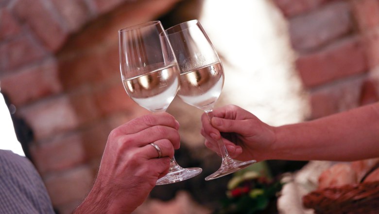 Dva lid&eacute; si přip&iacute;jej&iacute; naplněn&yacute;mi sklenicemi v&iacute;na.