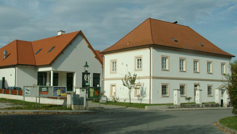 Fara ve Walpersbachu se dvěma budovami a červenou střechou.