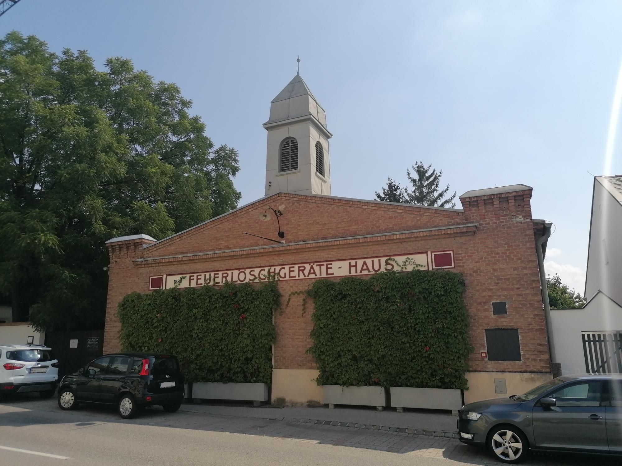 Stará hasičská stanice v Bad Fischau s cihlovou fasádou a věží.