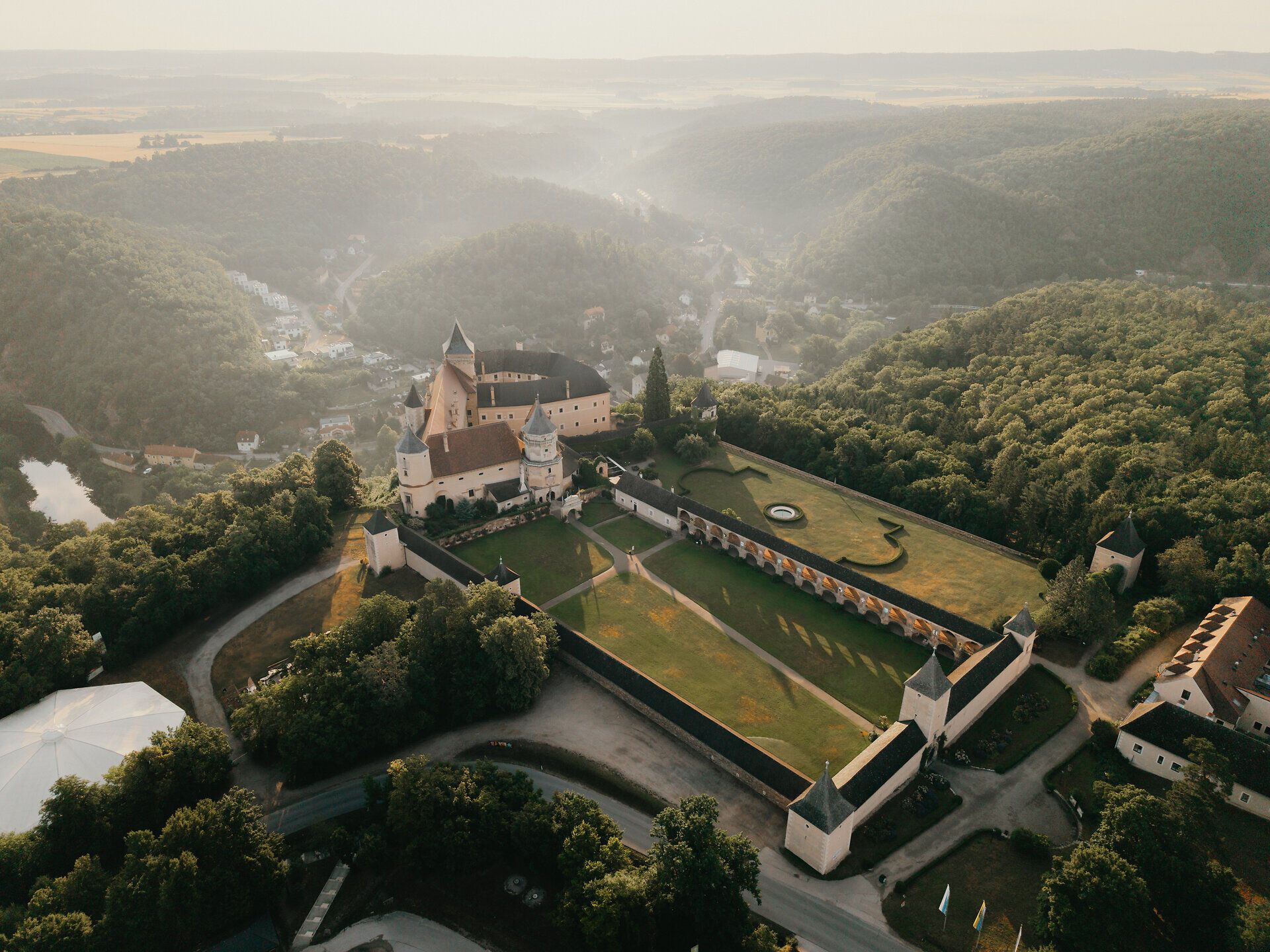 Letecký pohled na hrad Rosenburg obklopený lesem a kopci.