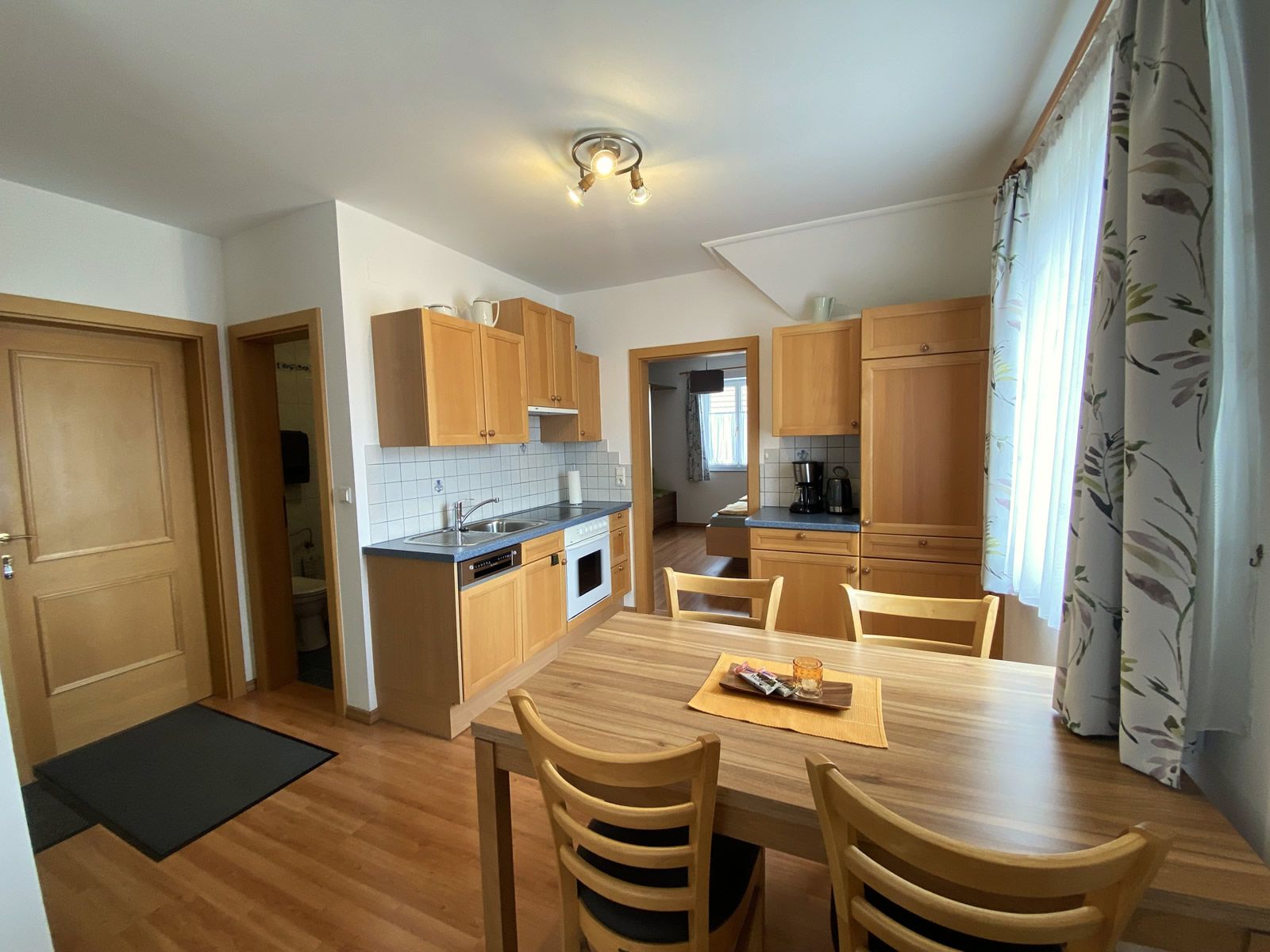 Pohled do interiéru rekreačního bytu s kuchyní a jídelním stolem.