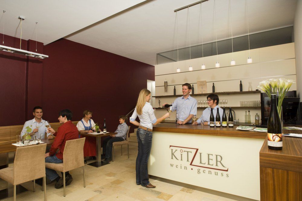 Pohled do interiéru vinárny s hosty a personálem.