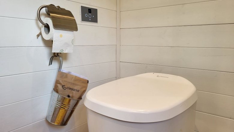 Bezvod&eacute; WC Clesana se svařov&aacute;n&iacute;m s&aacute;čků v m&iacute;stnosti s dřevěn&yacute;m obložen&iacute;m.