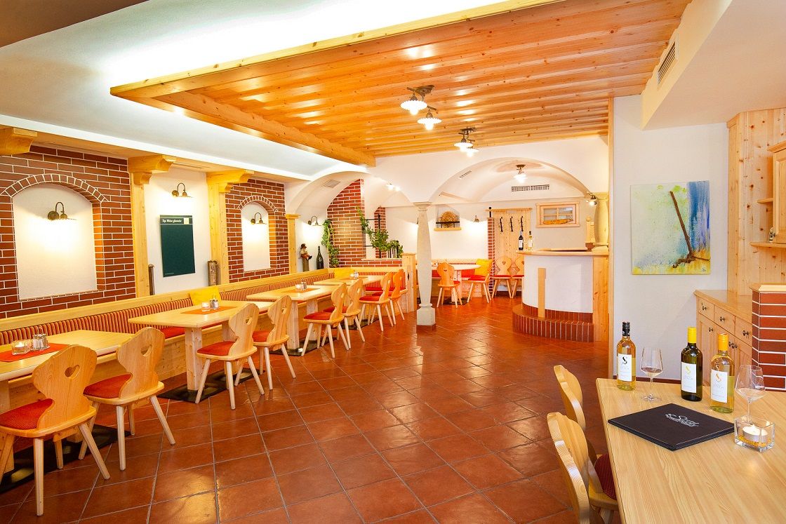 Útulná restaurace s dřevěným nábytkem a cihlovými zdmi.