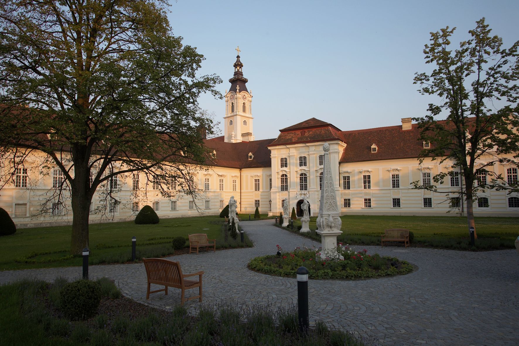 Opatství Altenburg se zahradou a sochami v popředí.