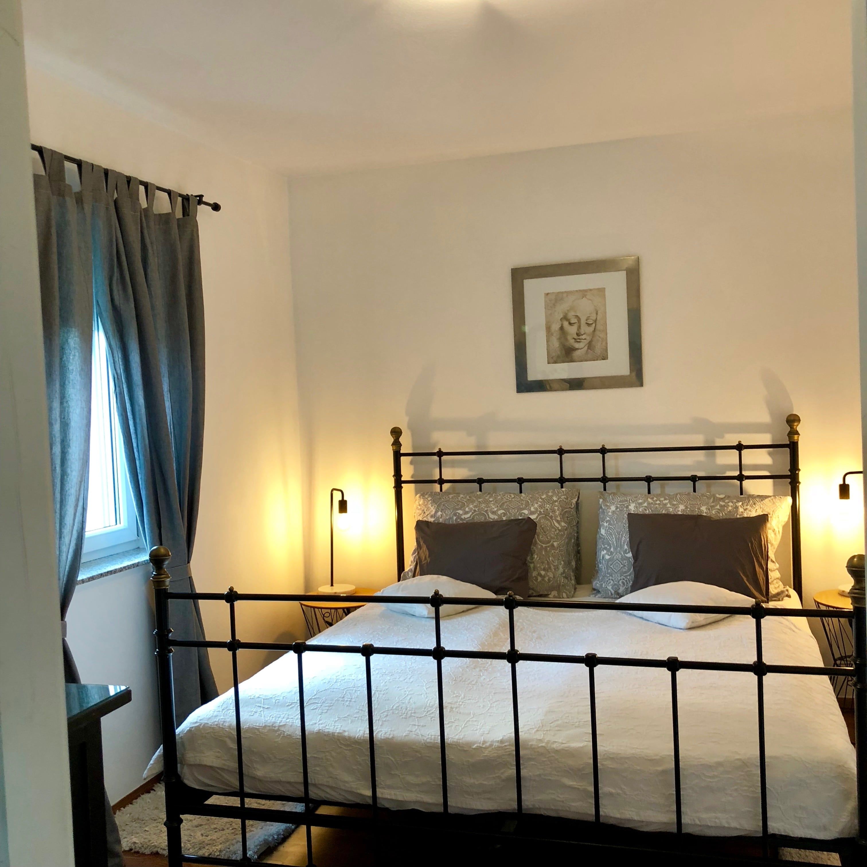 Jednoduše zařízená ložnice s postelí a klidnou atmosférou.