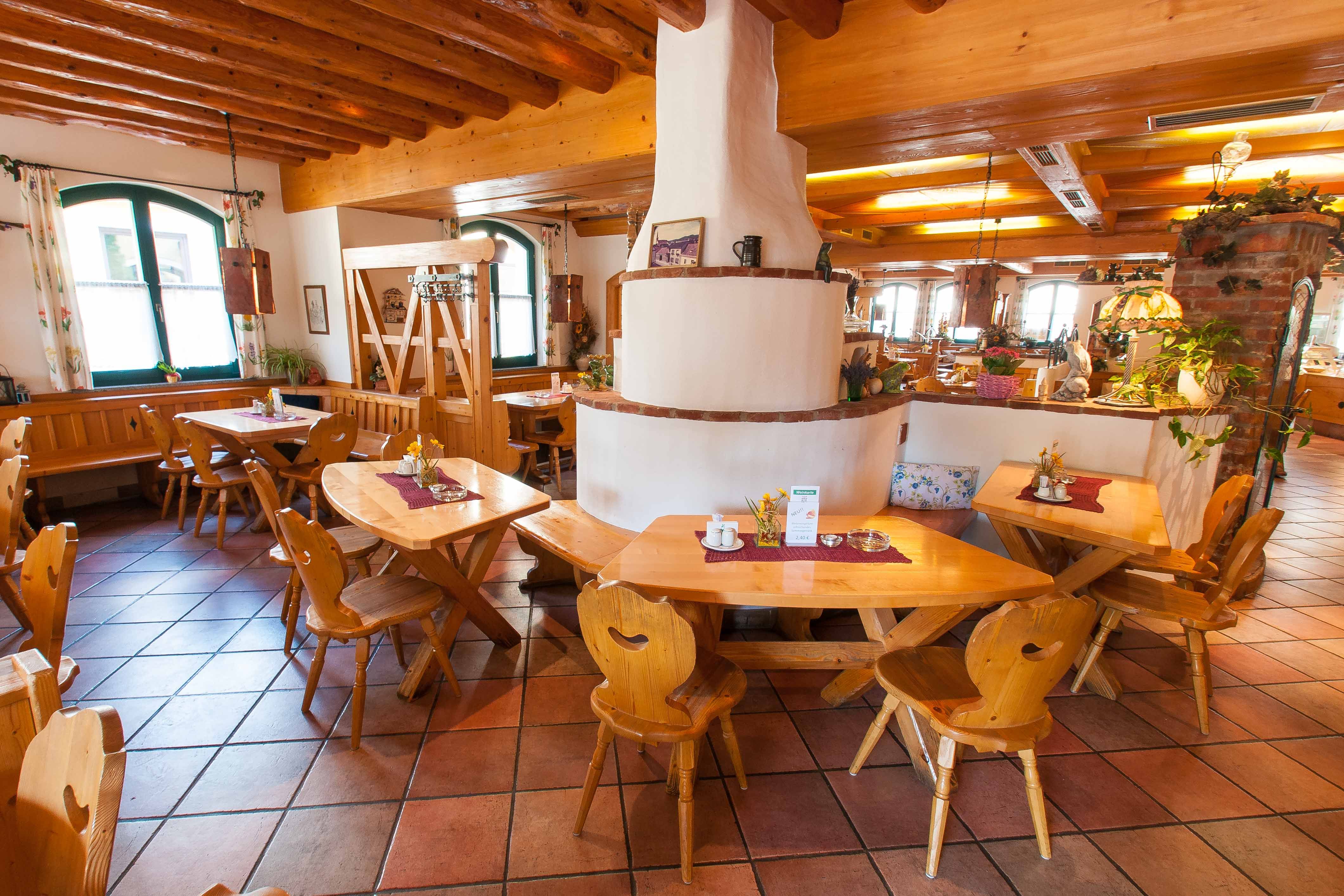 Útulná restaurace s dřevěným nábytkem a rustikální výzdobou.