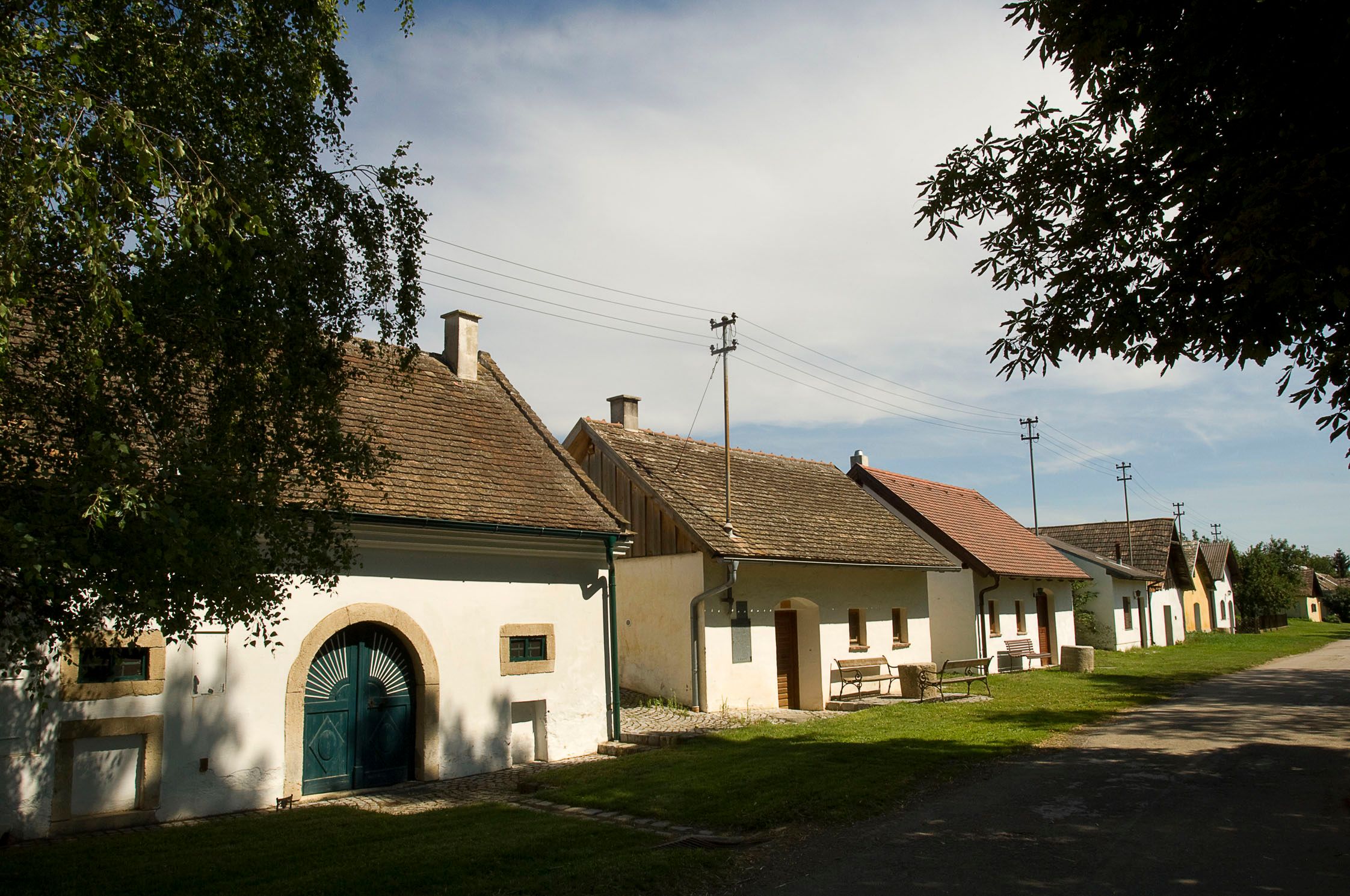 Řada tradičních vinných sklepů v rakouském Grabernu za slunečného počasí.
