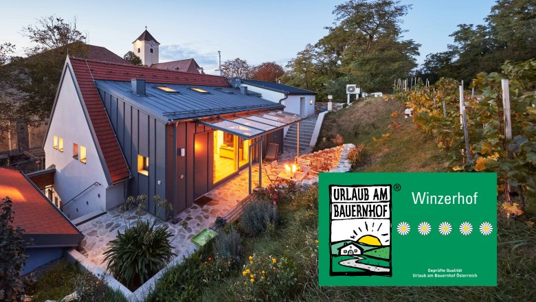 Weinviertler Kellerstöckl, © Andreas Hofer Moderní sklep ve Weinviertelu za soumraku, obklopený vinnou révou a zahradou. Nápis "Dovolená na statku".