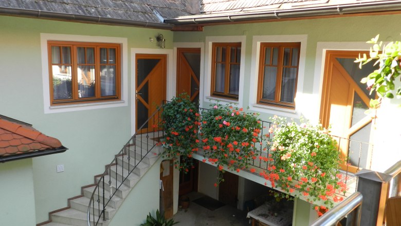 Vnitřn&iacute; dvůr se schody, květinami a stolem.