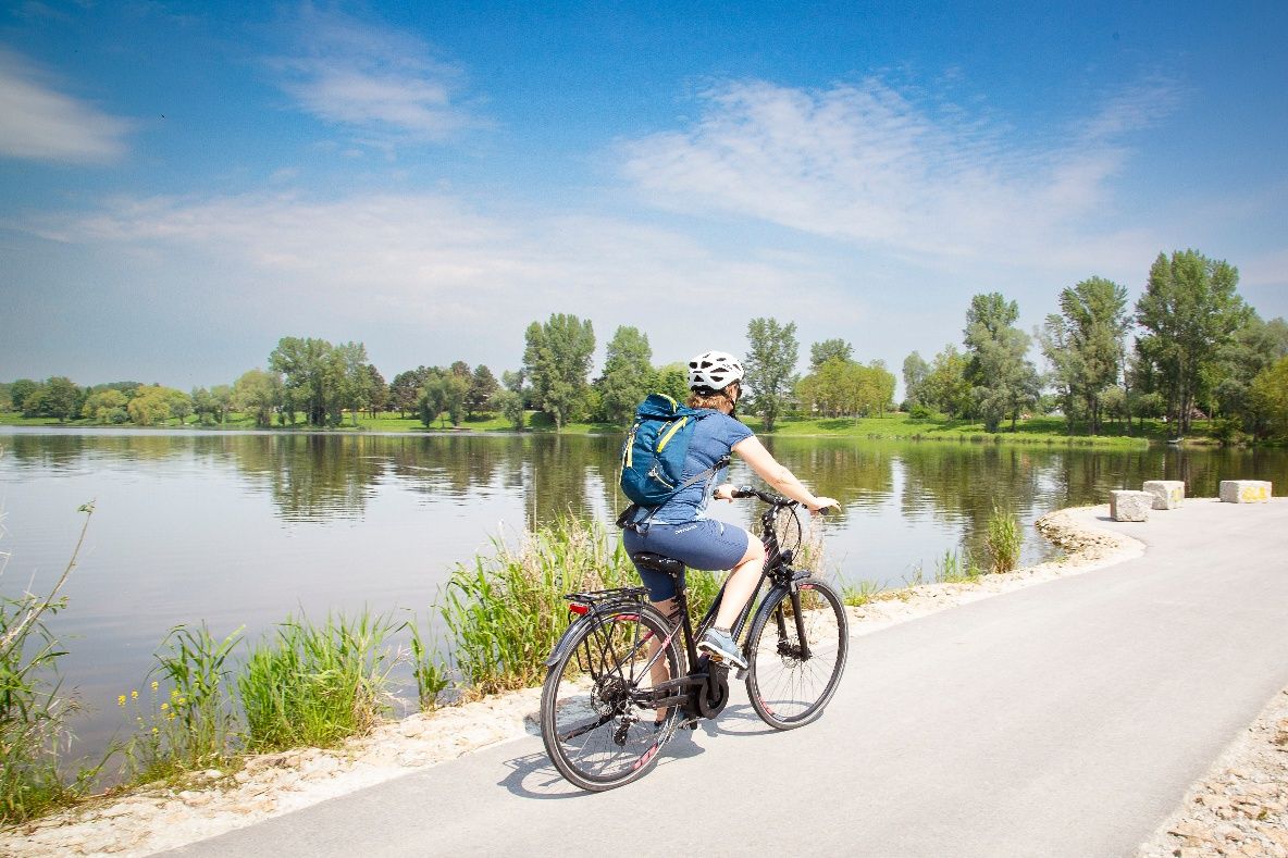 Cyklisté podél Dunaje v idylické říční krajině