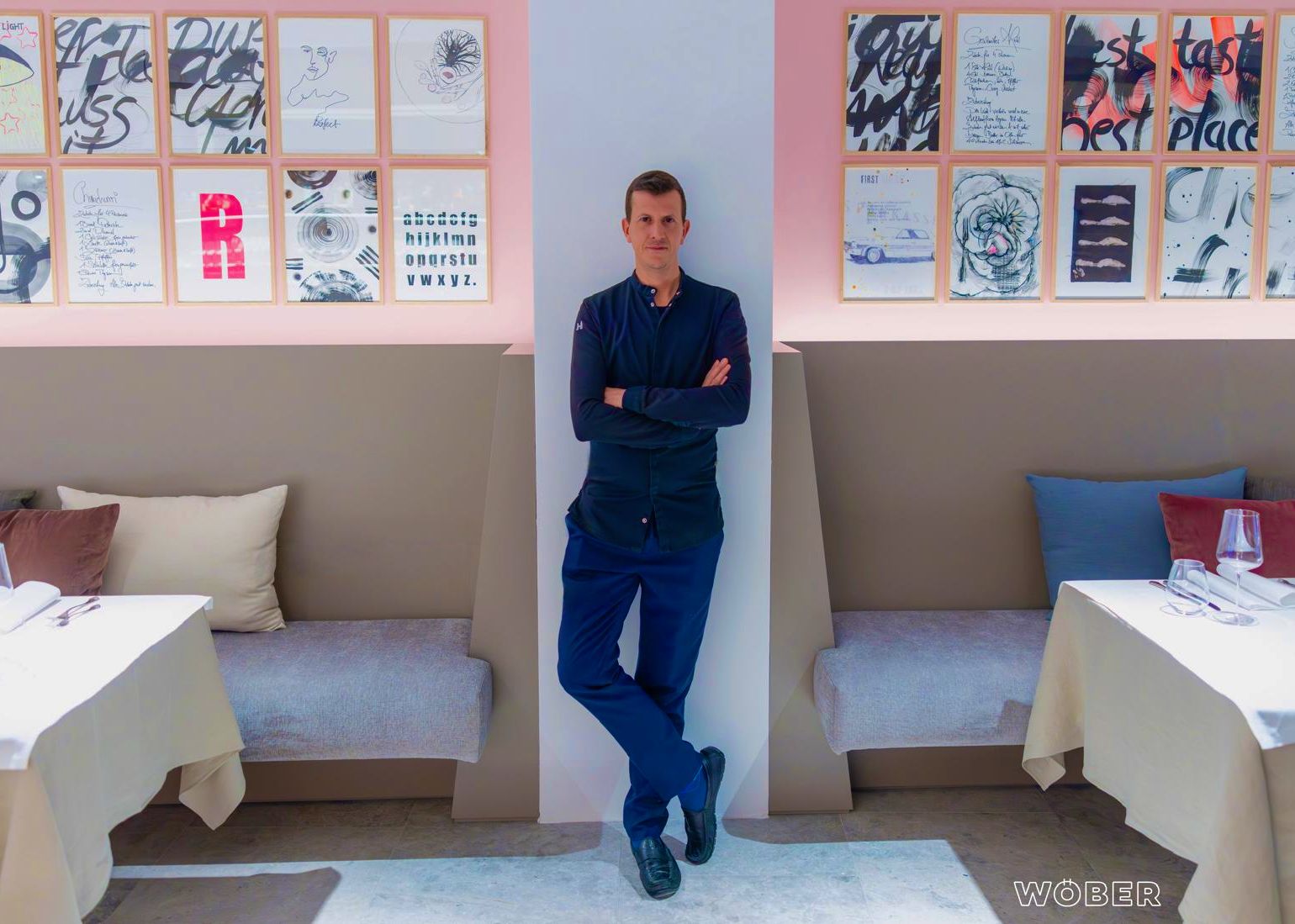 Majitel před stěnou v restauraci 