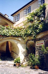 Historická budova s rostlinami a oblouky.