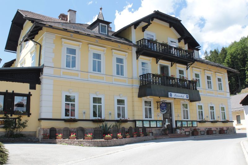Žlutá budova s balkonem a květinovými truhlíky, Land-Pension Kaiserhof.