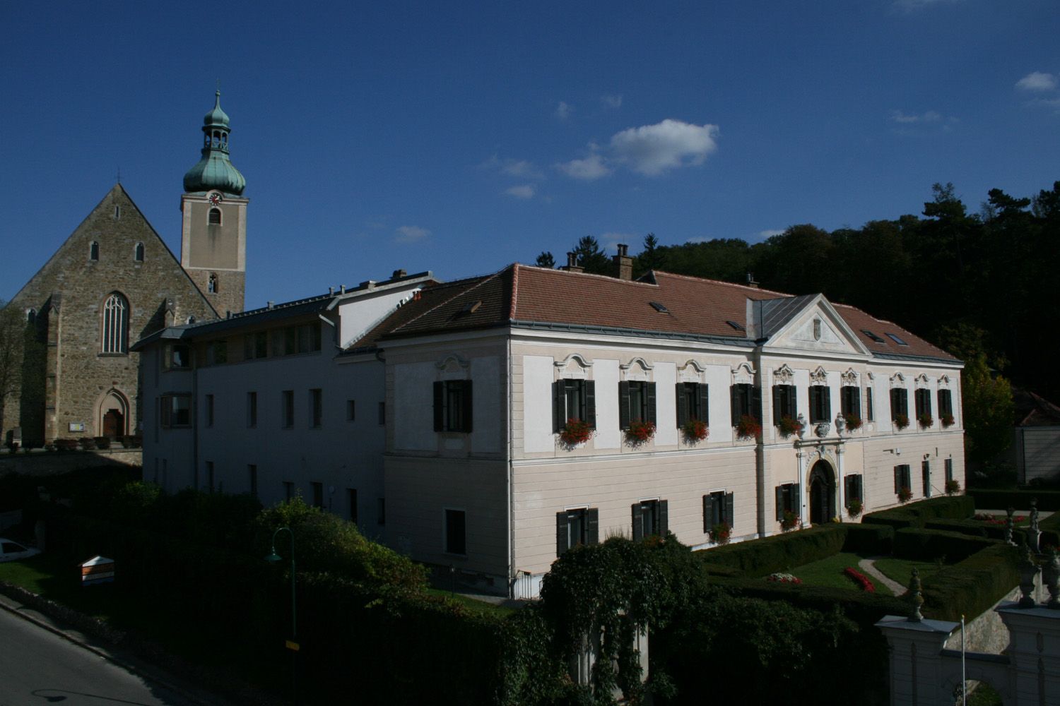 Vzdělávací centrum zámku Großrußbach s kostelem v pozadí.