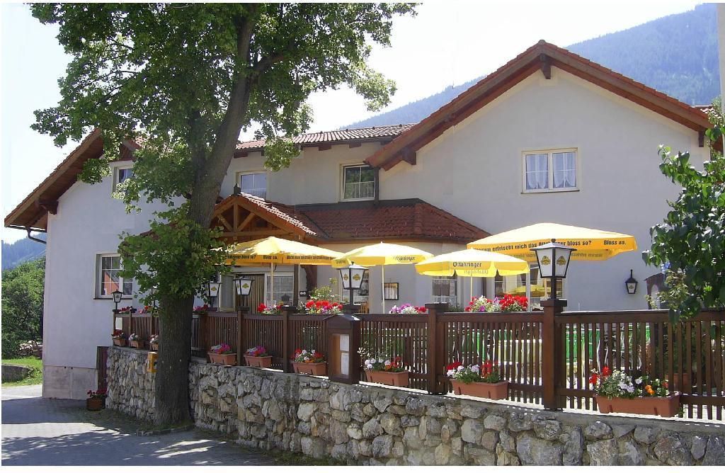 Hostinec s terasou a žlutými slunečníky.