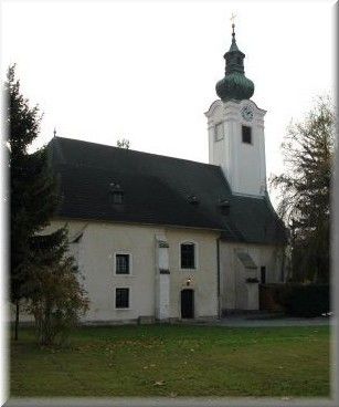 Kostel s věží a zelenou střechou ve Schwadorfu.